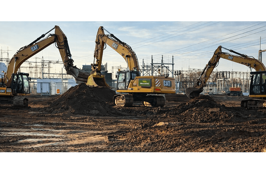 A Maveric vacuum-excavation truck with its suction boom deployed beside a data-centre building under construction.