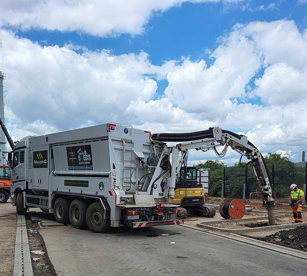 Maveric vacuum-excavation truck with its suction boom deployed on a data-centre site.